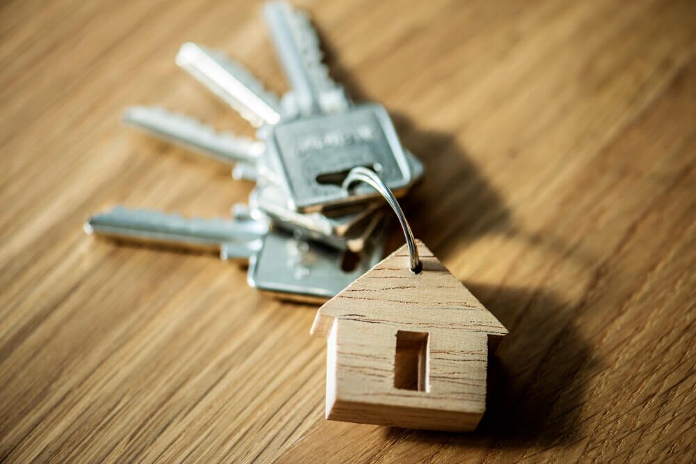 Keys with wooden house keychain suggesting home rental